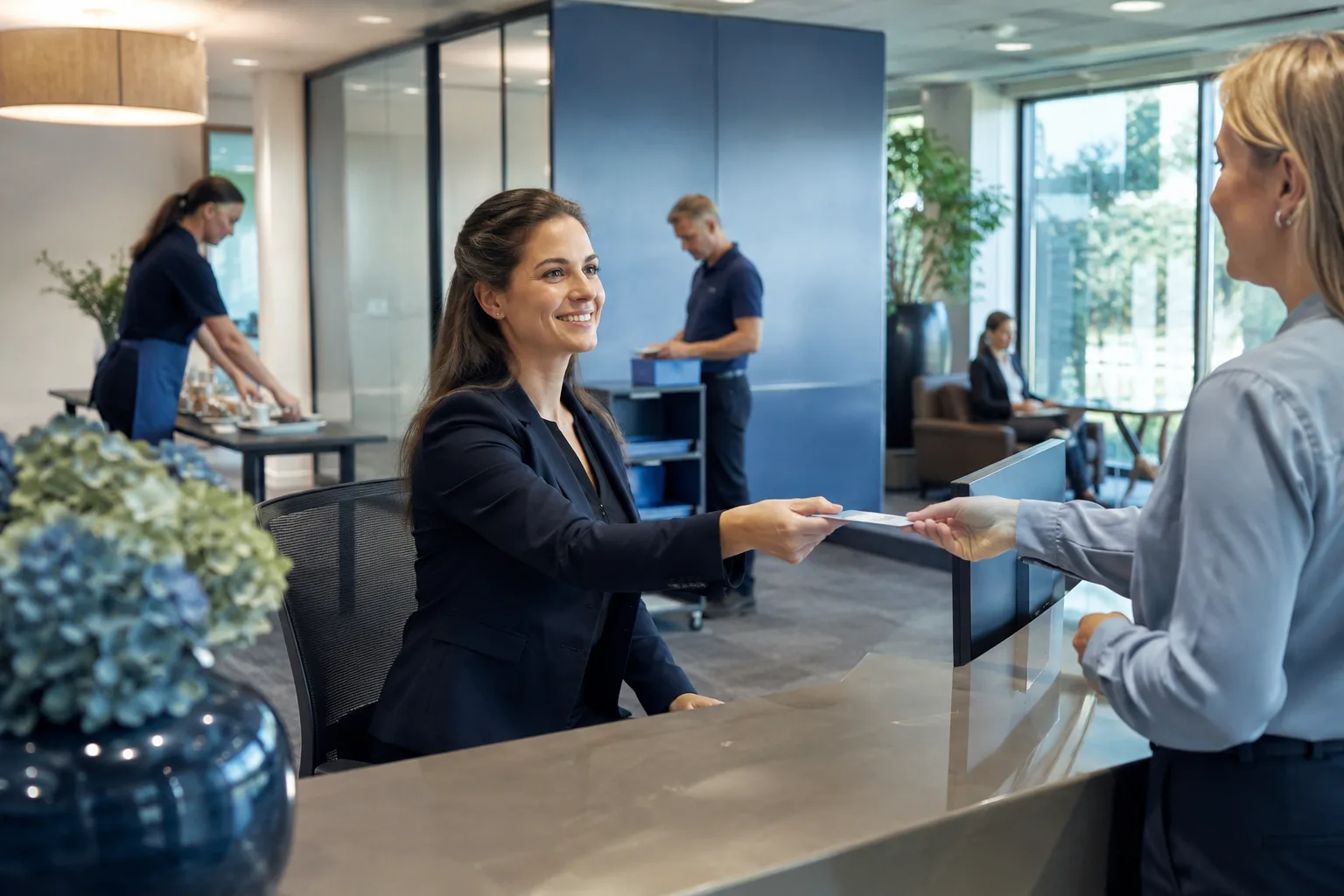 Facilitair medewerker Claritas begeleidt bezoekers bij de receptie van een modern kantoorgebouw
